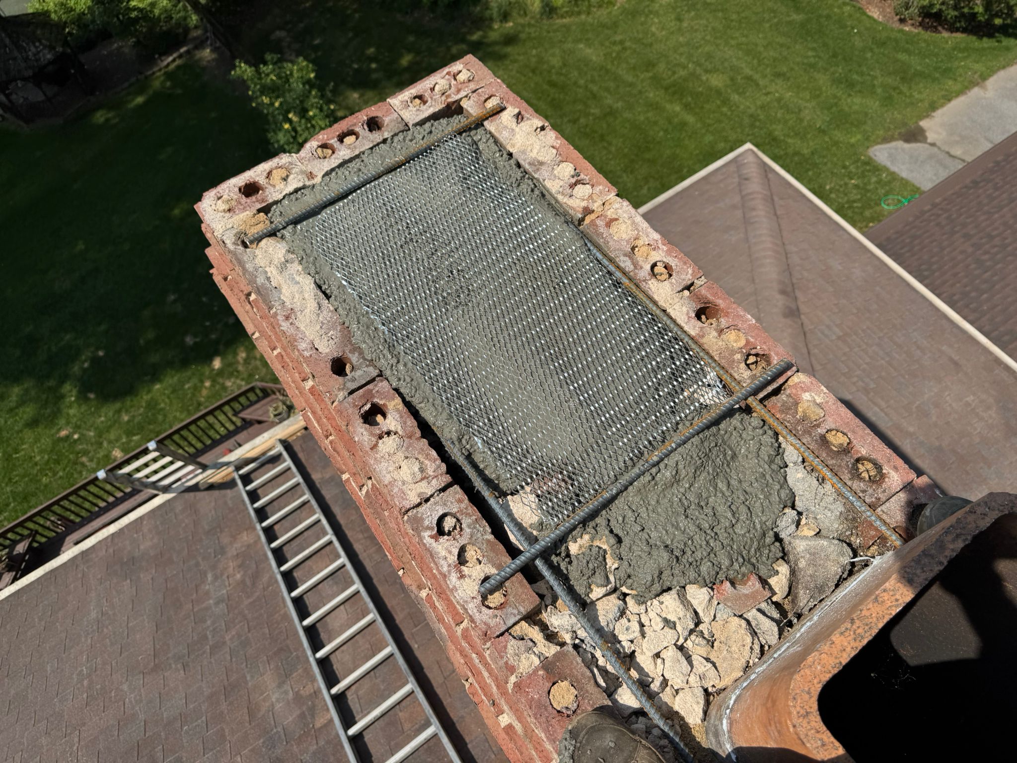 Metal chimney cap with mesh screen on brick chimney